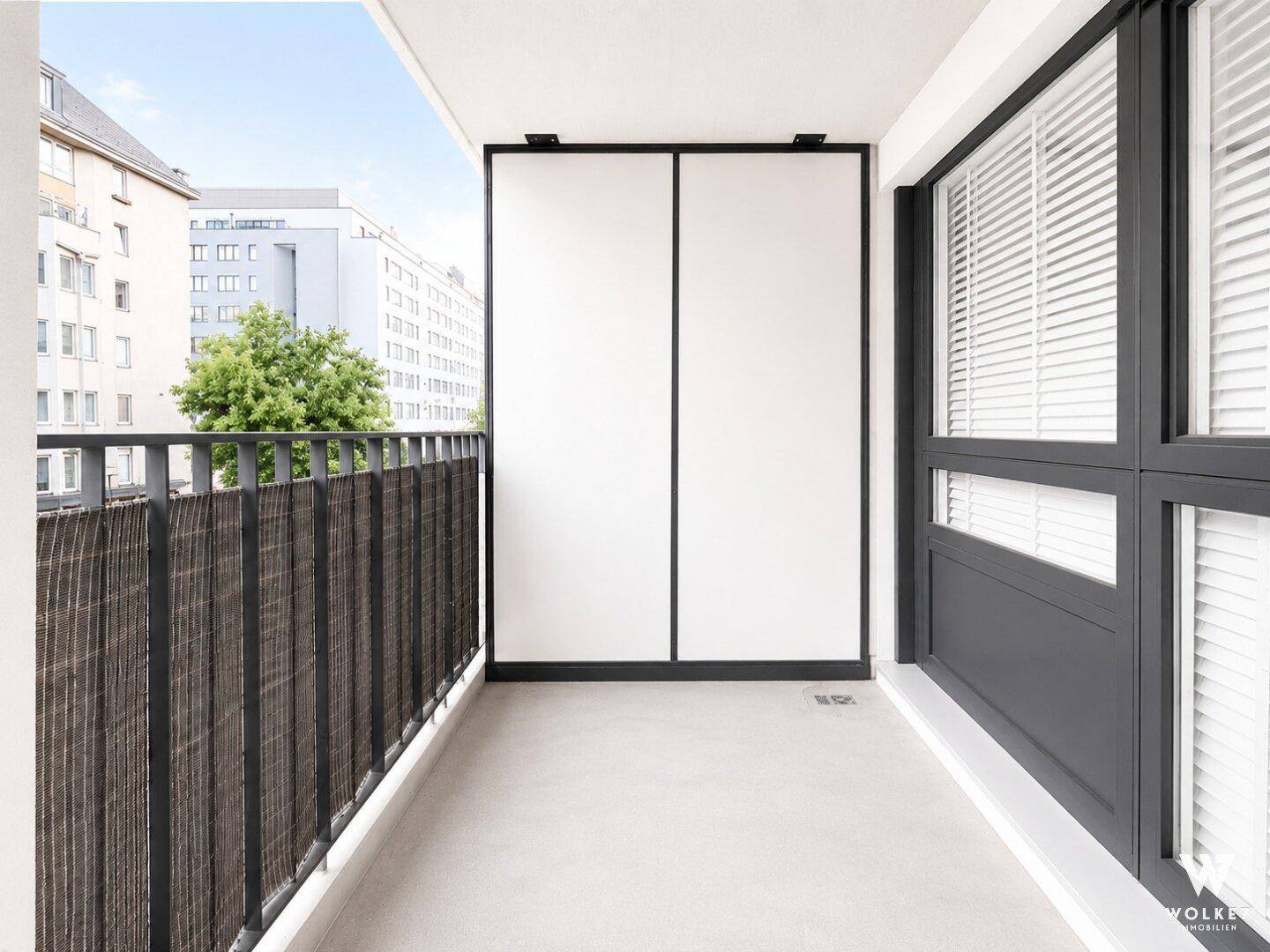 Leerer Balkon mit Blick auf die umliegenden Gebäude und viel Tageslicht.