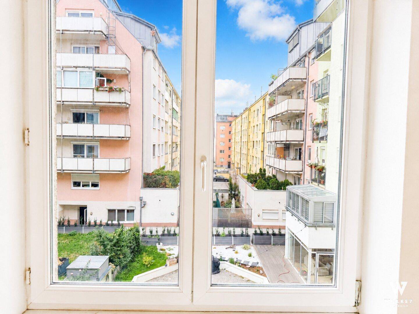 Ausblick aus dem Fenster auf die umliegenden Wohngebäude und einen Innenhof.