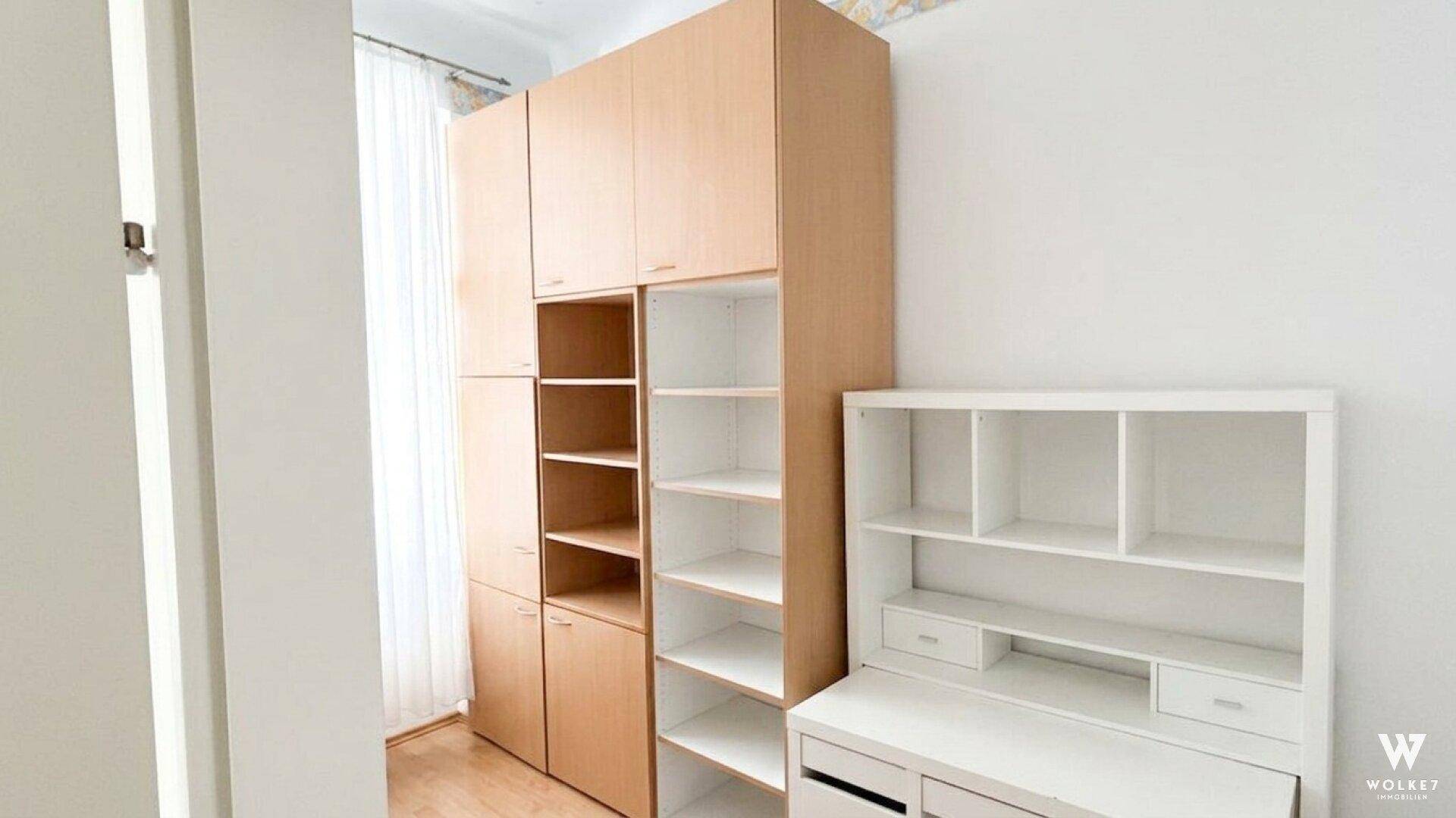 Funktionaler Raum mit Holzschränken und Schreibtisch, ideal als Büro oder Kinderzimmer.