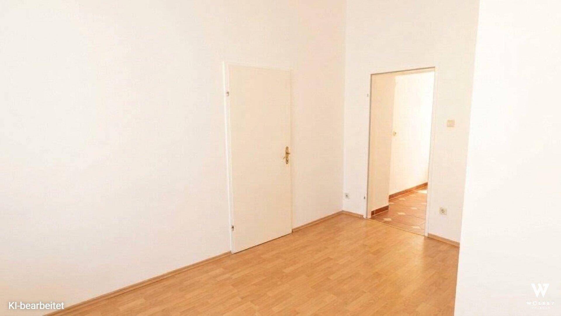 Heller Flur mit Holzboden und Zugang zu weiteren Räumen, einer davon gefliest.