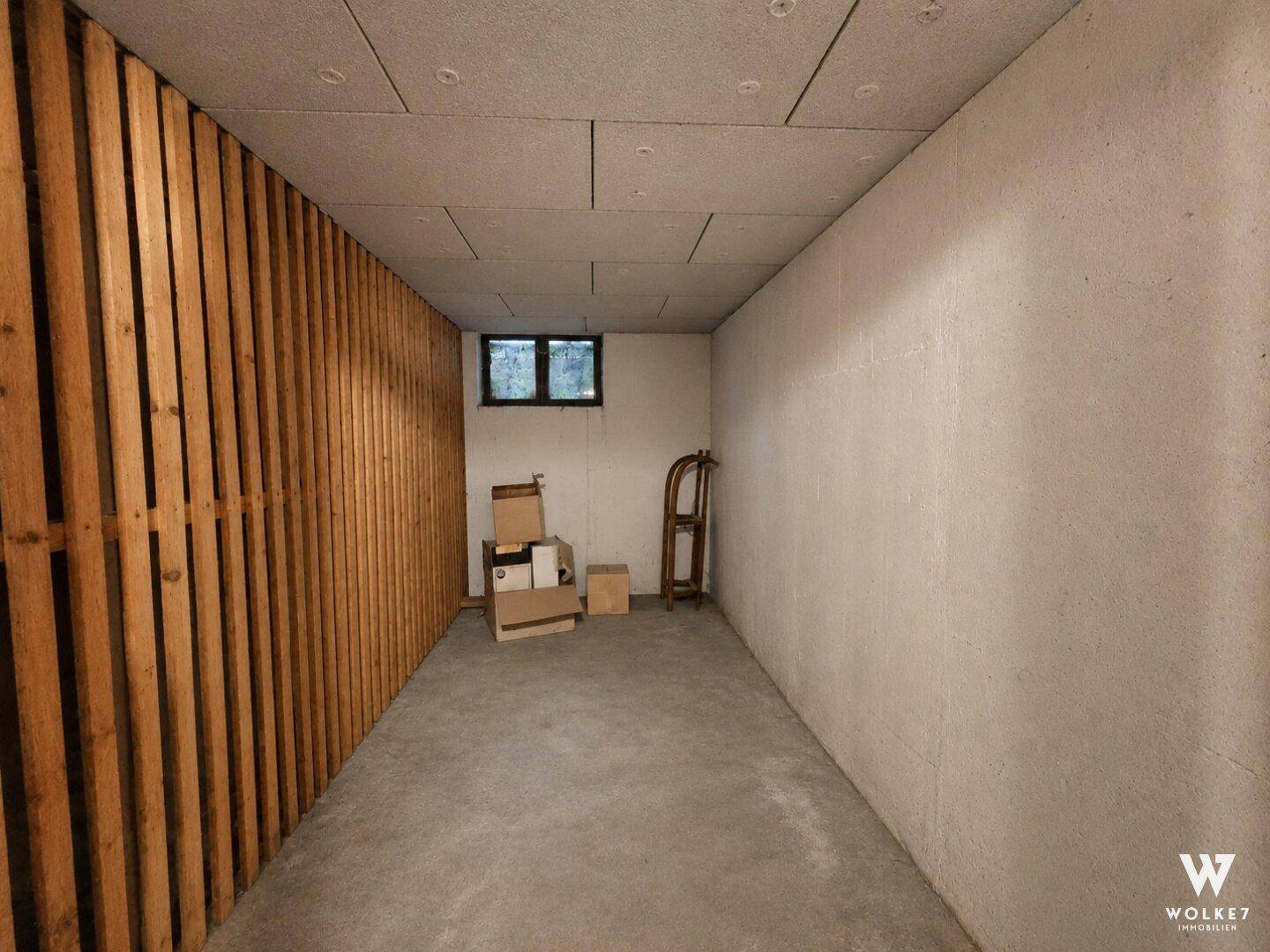 Praktischer Abstellraum oder Keller mit Betonboden und einer Holzwandverkleidung.