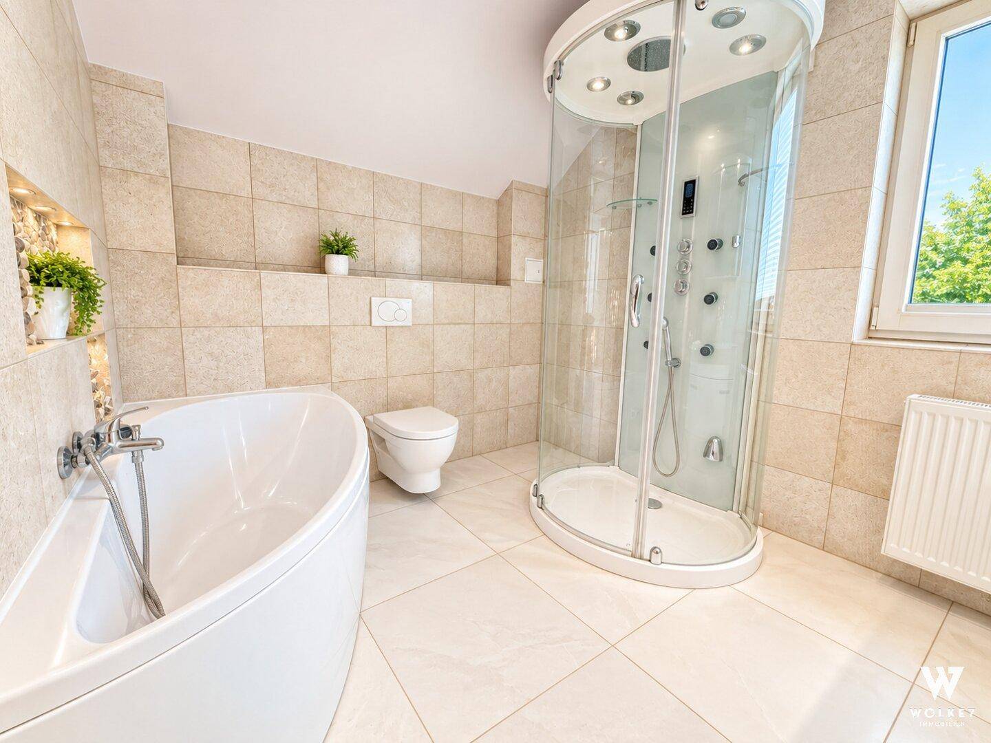 Geräumiges Badezimmer mit freistehender Badewanne, moderner Duschkabine und Fenster.
