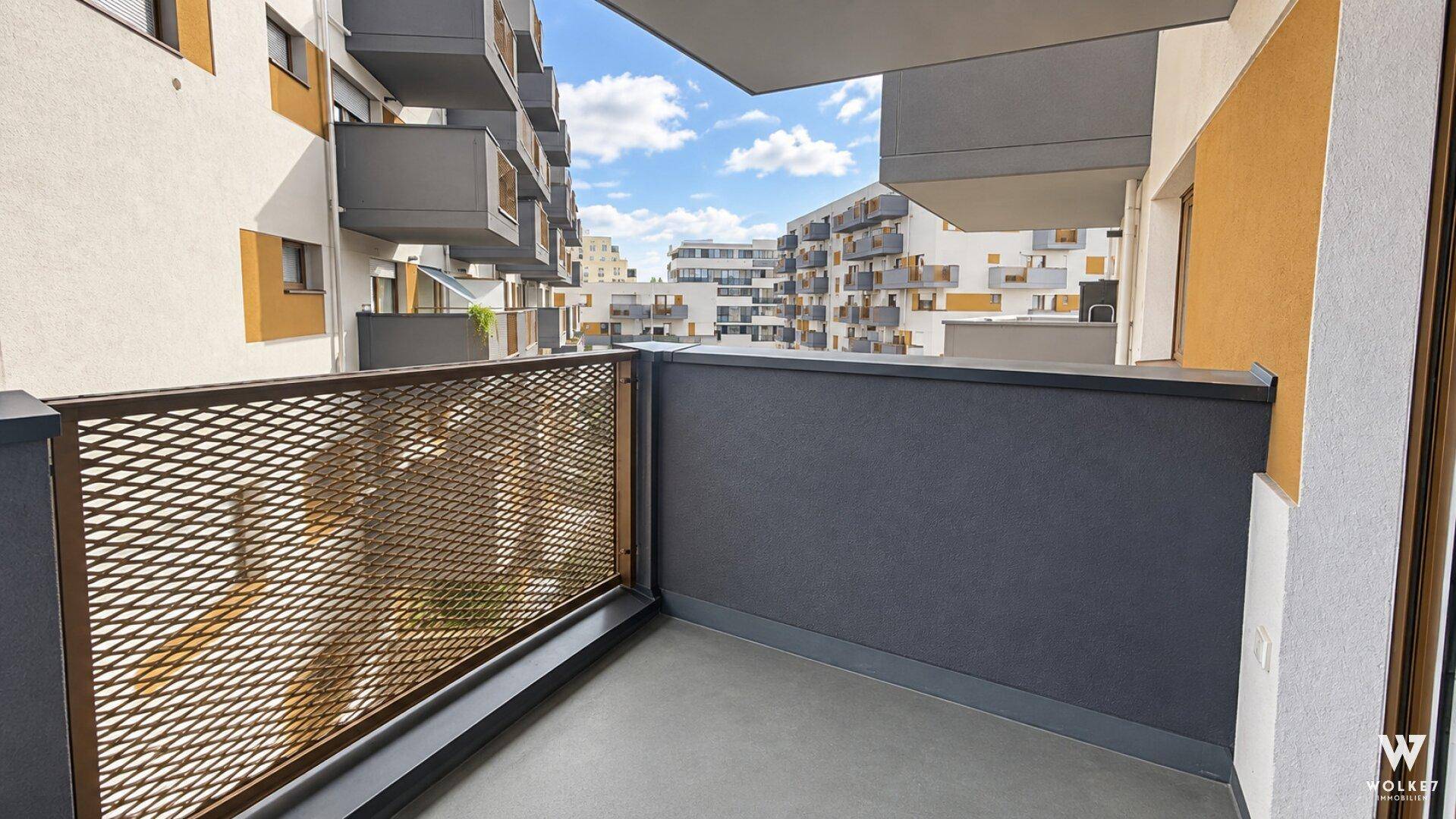 Balkon mit Metallgeländer und Blick auf die umliegenden modernen Wohngebäude.