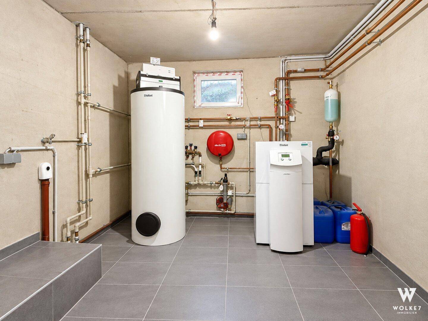 Technikraum mit Heizungsanlage, Warmwasserspeicher und Wasseraufbereitungssystem.