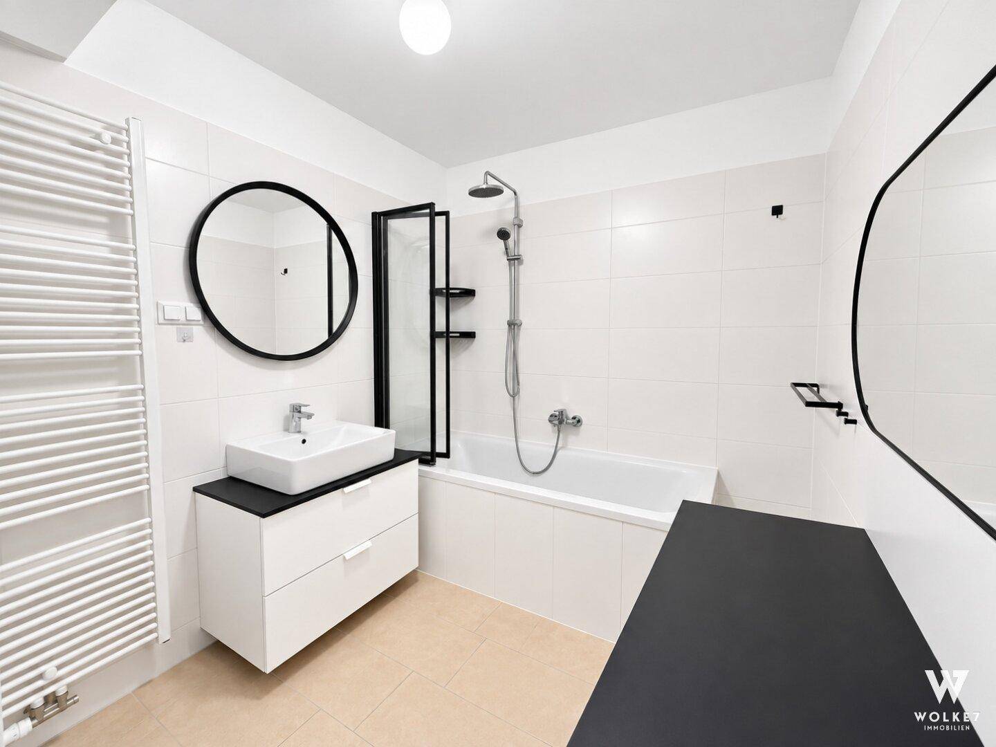 Modernes Badezimmer mit Badewanne, Dusche, stilvollem Waschtisch und beheiztem Handtuchhalter.