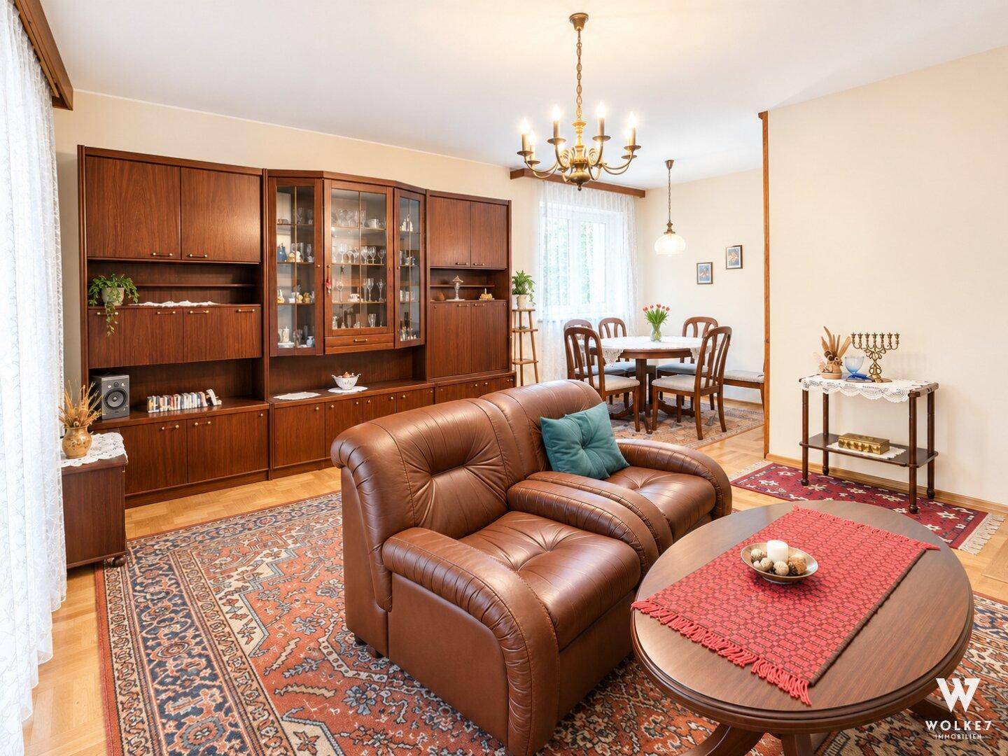 Gemütliches Wohn- und Esszimmer mit traditionellen Holzmöbeln, klassischem Teppich und natürlichem Lichteinfall.