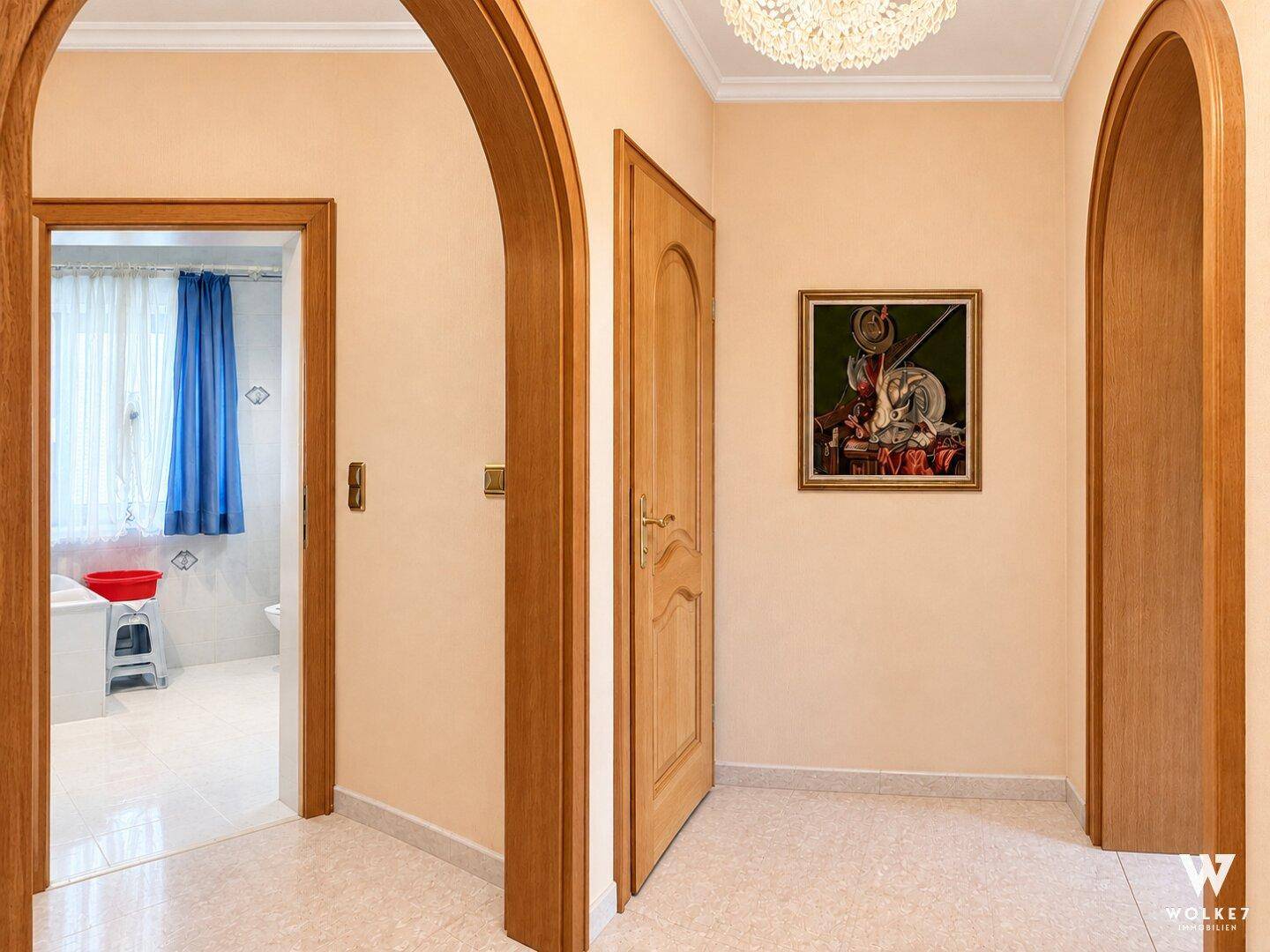 Heller Flur mit eleganten Rundbögen und Zugang zu verschiedenen Zimmern.