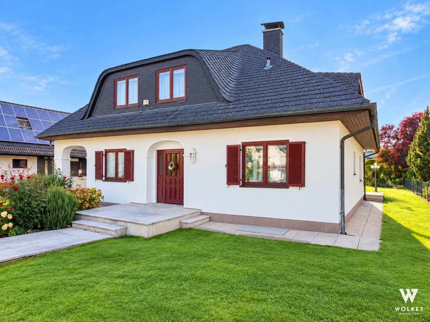 Ansicht des Hauses von der Seite mit gepflegtem Rasen und traditioneller Architektur.
