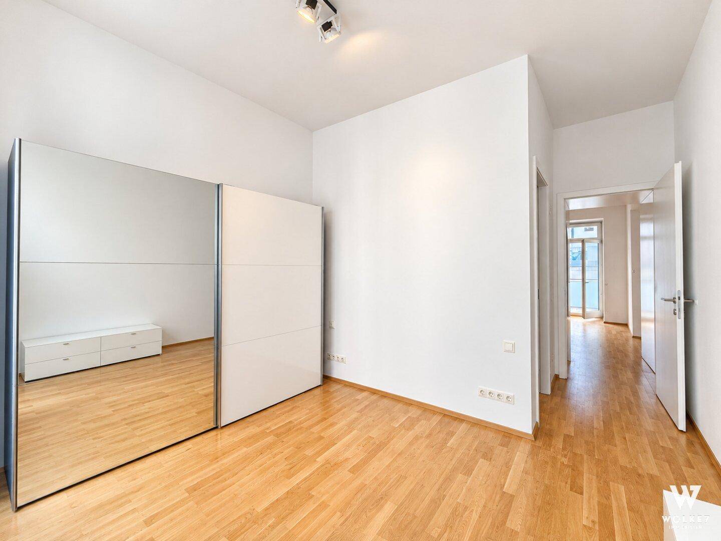 Geräumiges Zimmer mit Spiegelschrank und Blick in den Flur.