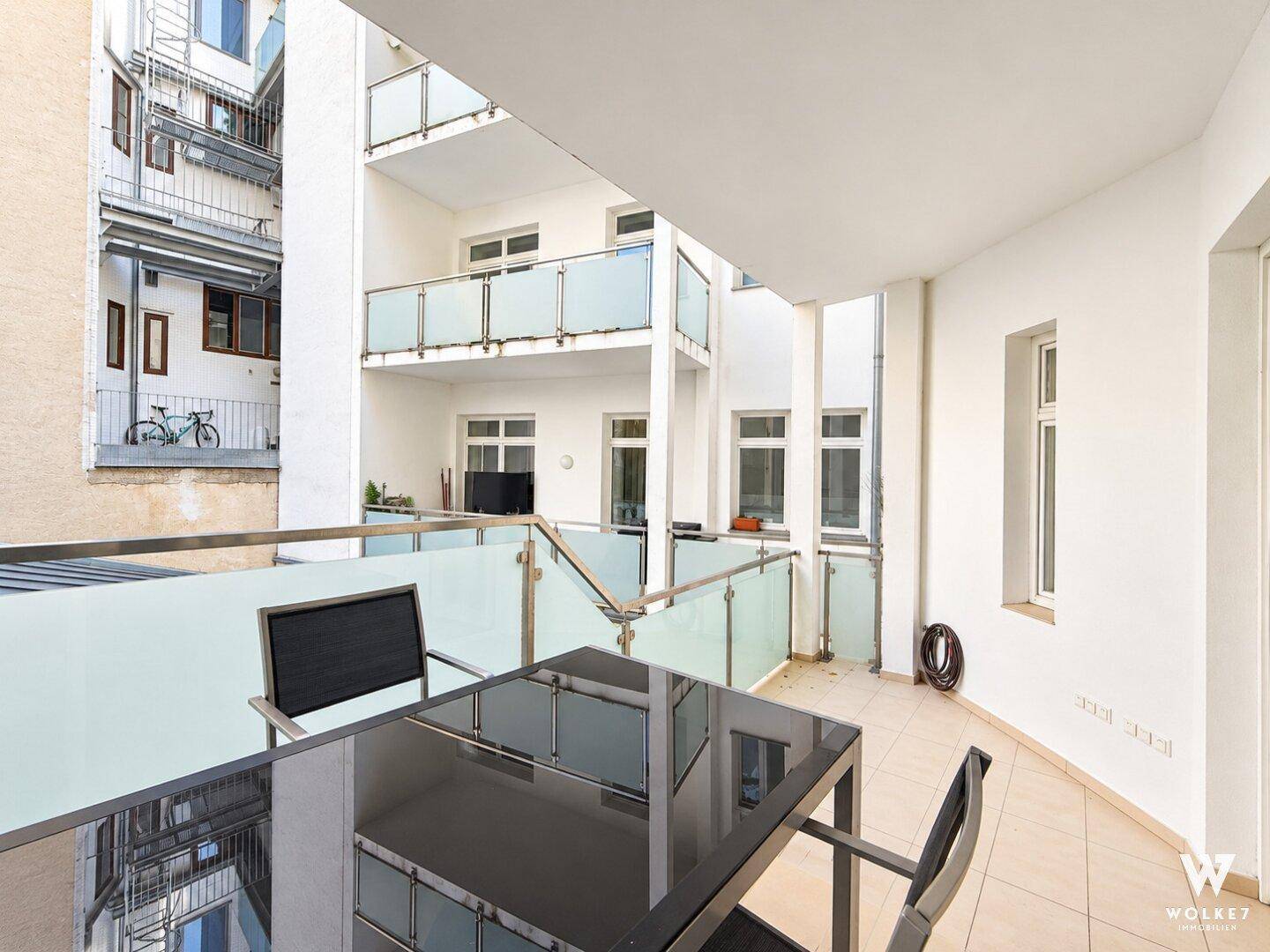 Geräumiger Balkon mit Blick auf den Innenhof und weitere Balkone.