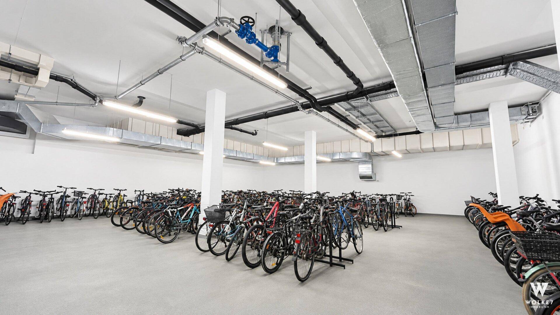 Großer Fahrradraum mit zahlreichen Stellplätzen und sichtbaren Installationen.