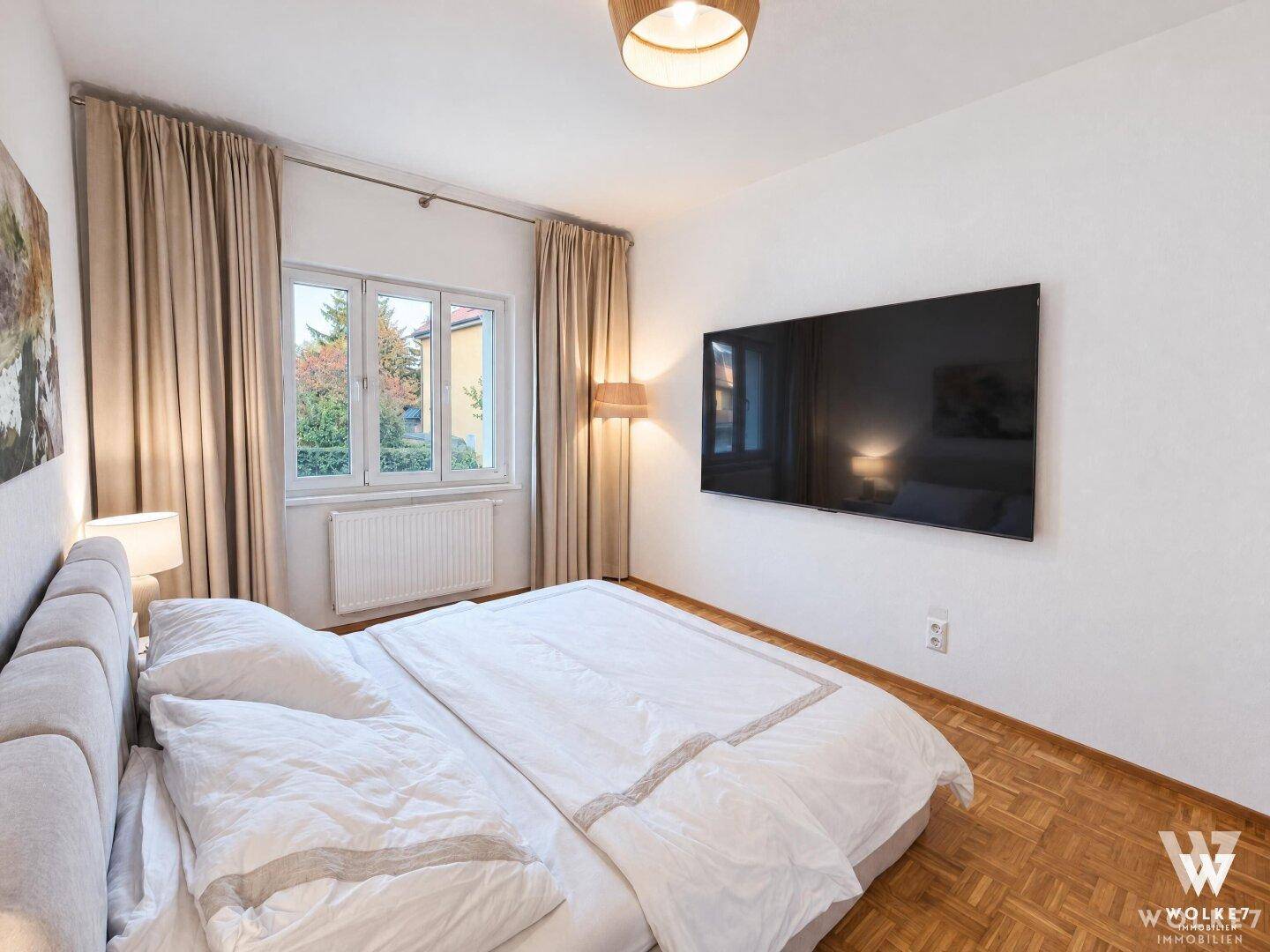 Schlafzimmer mit großem Fenster und TV