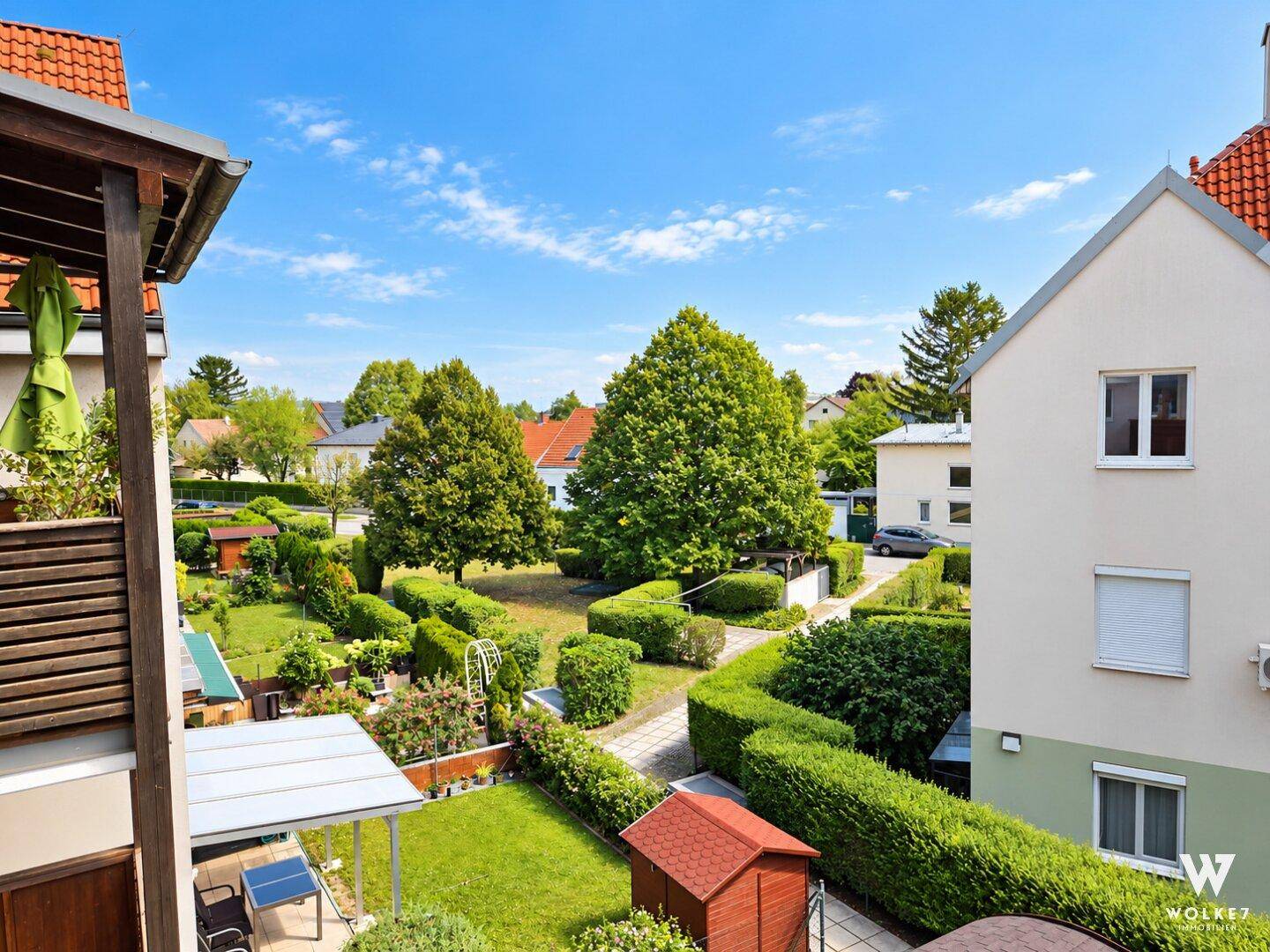 Weitläufiger Blick auf die gepflegte Gartenanlage und die umliegenden Häuser.