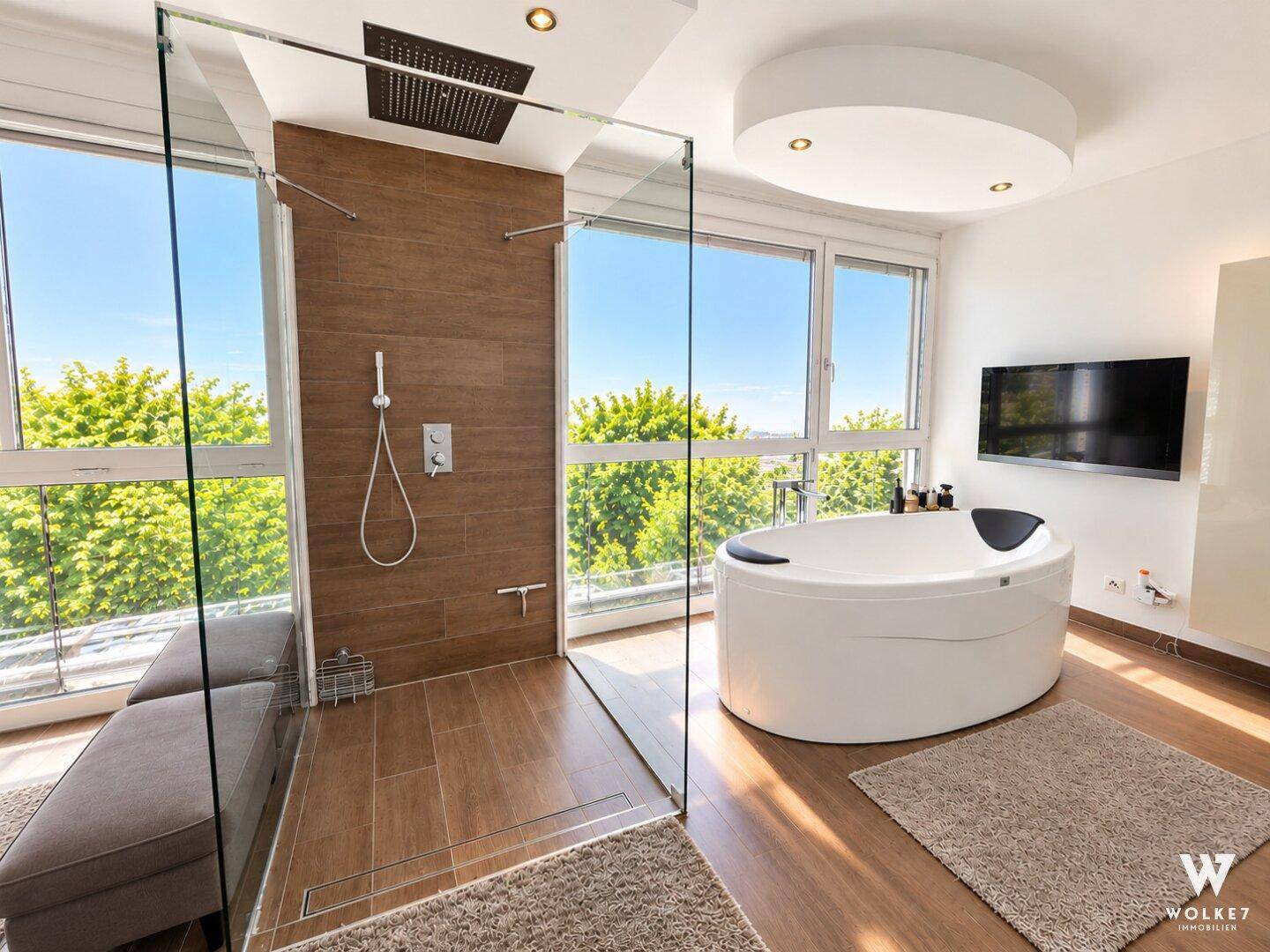 Luxuriöses Badezimmer mit freistehender Badewanne, begehbarer Dusche und Panoramafenstern.