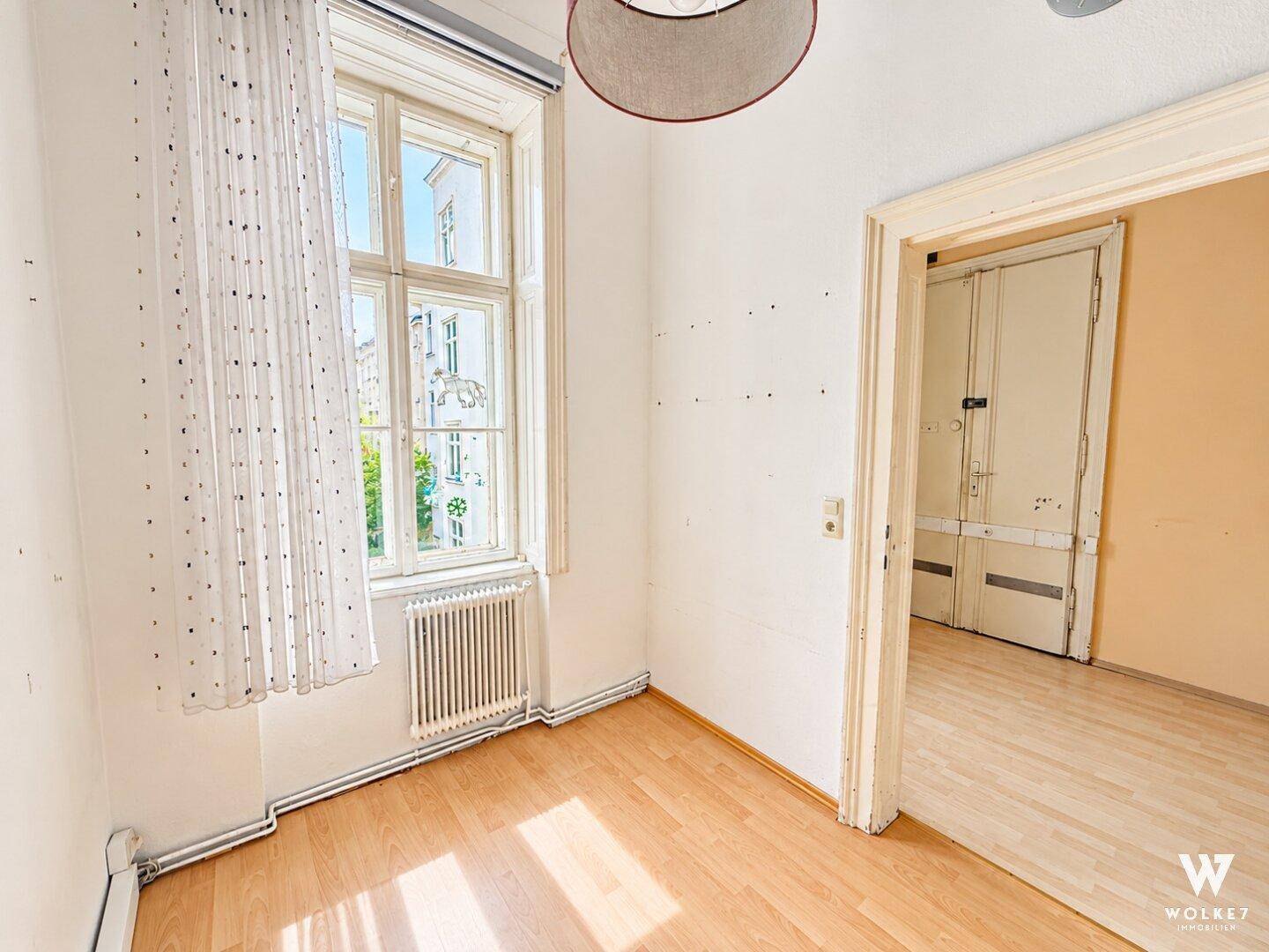 Kleines, helles Zimmer mit Laminatboden und einem Fenster, das den Raum mit Tageslicht versorgt.