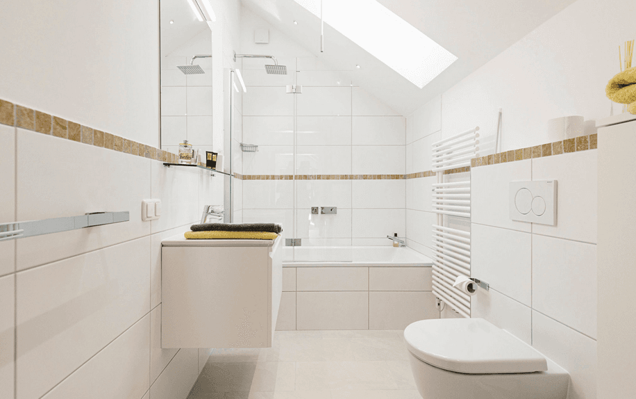 Modernes Badezimmer mit Badewanne, Dusche, Dachfenster und weißen Fliesen.
