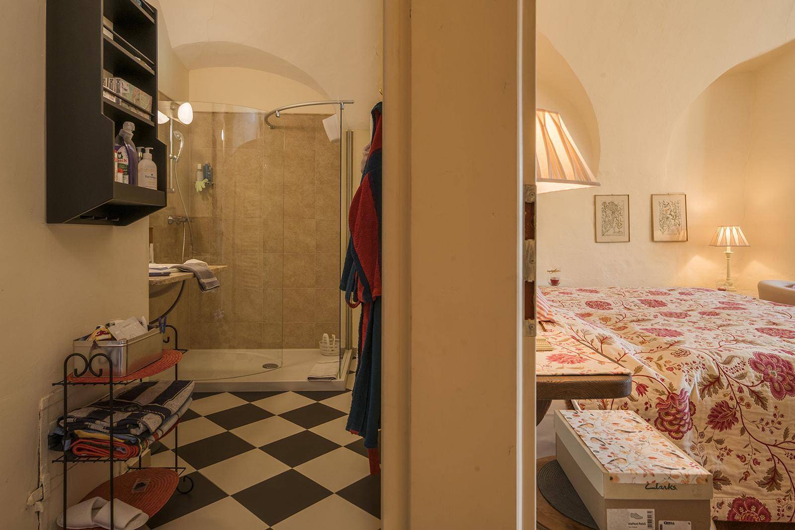 Gemütliches Schlafzimmer mit traditionellem Dekor und angrenzendem Badezimmer mit Dusche.