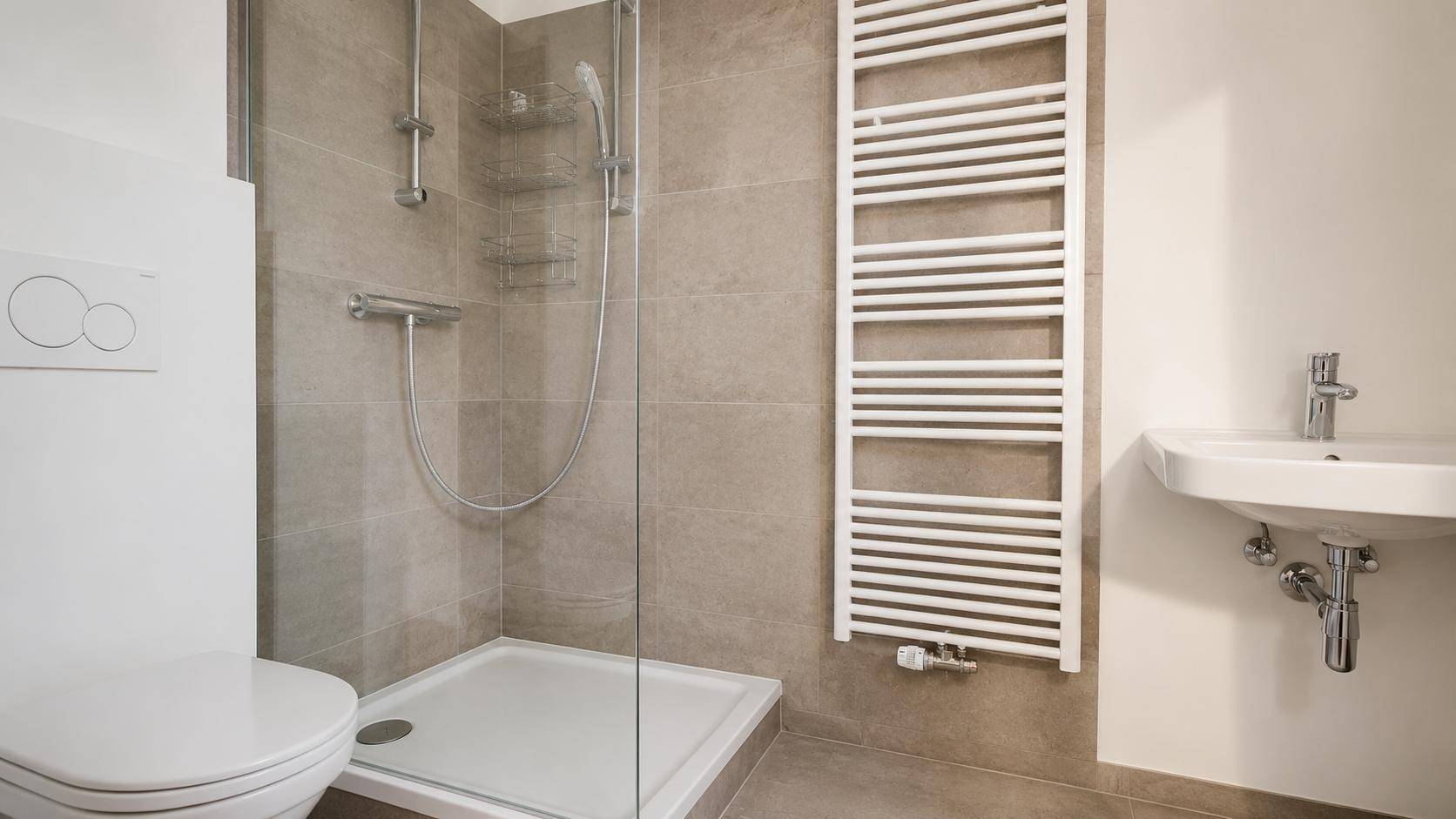 Modernes Badezimmer mit ebenerdiger Dusche, wandhängendem WC und beheiztem Handtuchhalter.