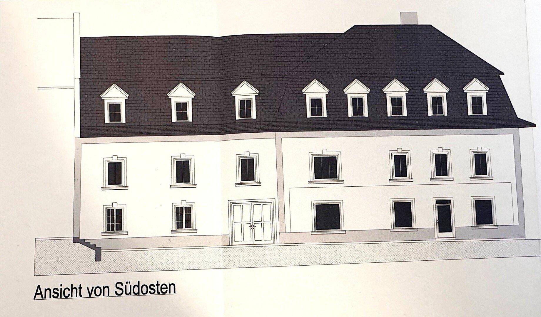 Ansicht der Südostfassade des Gebäudes mit mehreren Fenstern und einem großen Eingangsbereich.