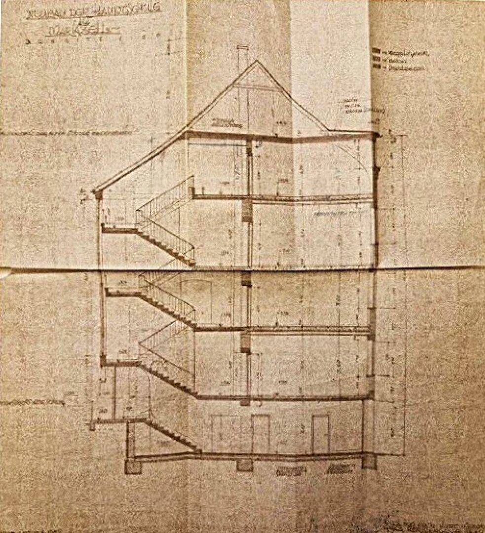 Historischer Gebäudeschnitt mit sichtbarem Treppenhaus und mehreren Etagen auf gefaltetem Papier.