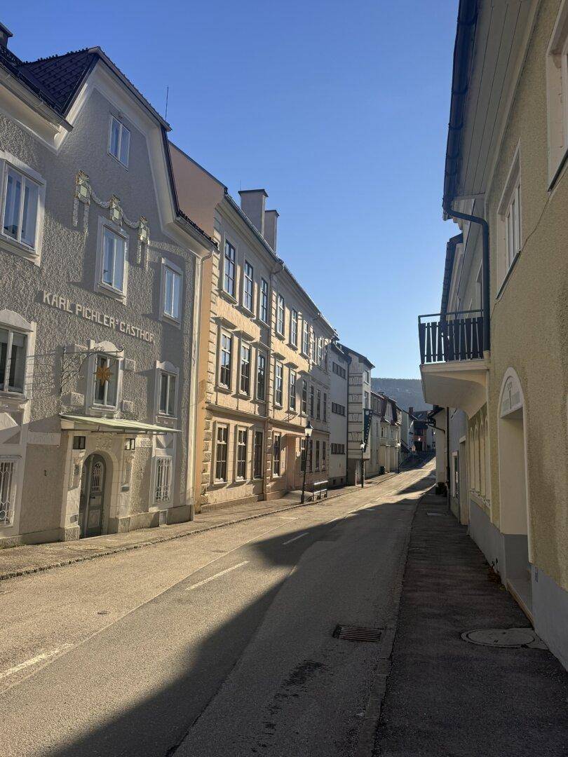 Historische Straße mit charmanten Gebäuden und einem Balkon an einem der Häuser.