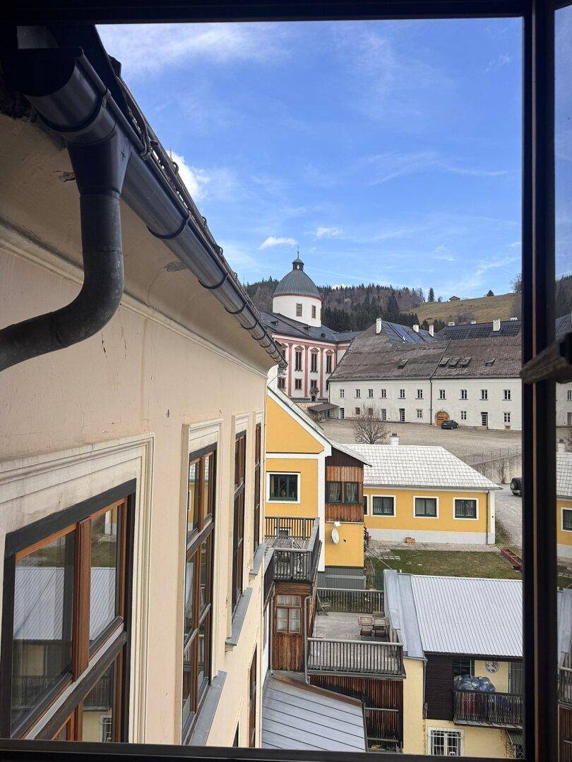 Blick aus dem Fenster auf Dächer, historische Gebäude und eine beeindruckende Kirche.