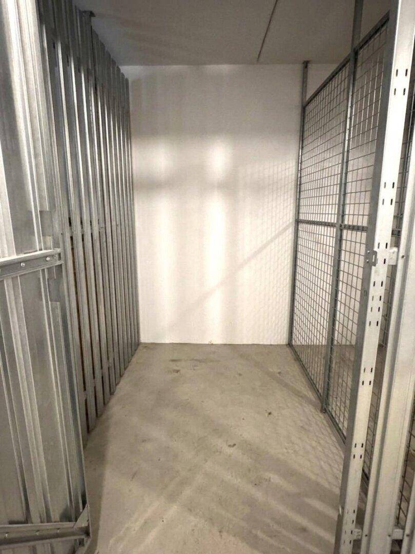 Geräumiger Abstellraum im Keller mit Metallabtrennungen für individuelle Lagereinheiten.