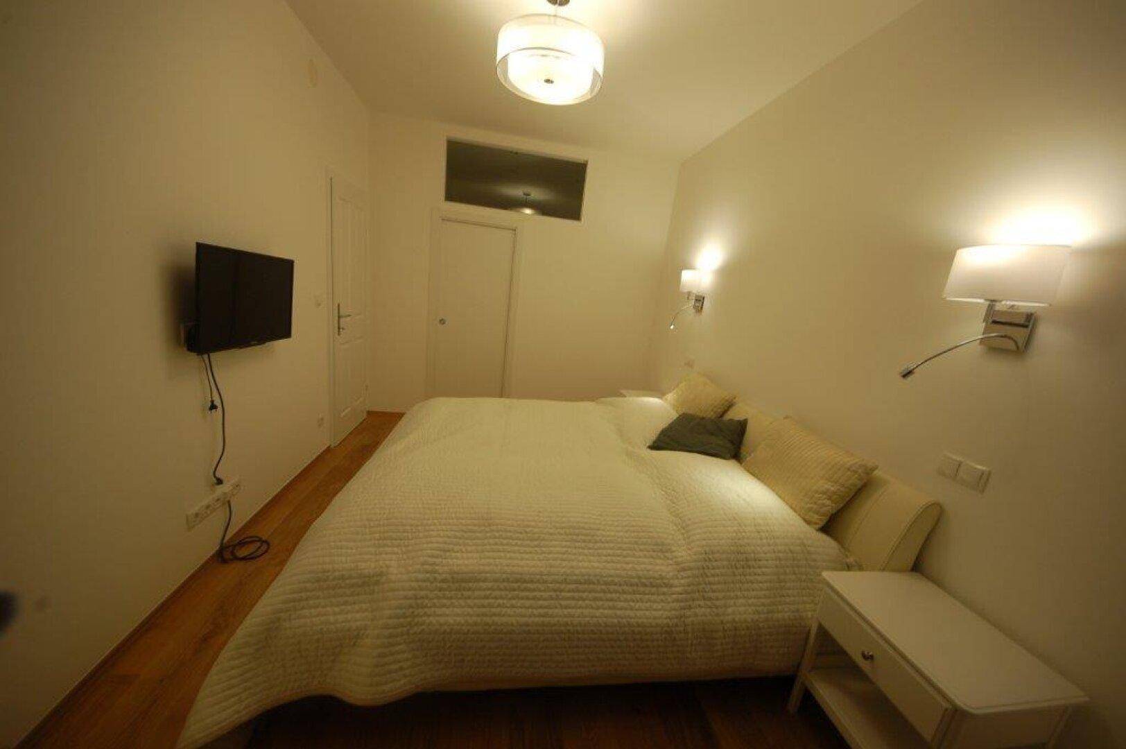 Schlafzimmer mit bequemen Doppelbett und schlichten Wandleuchten.