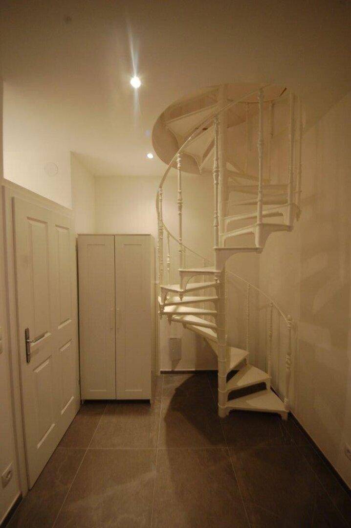 Flur mit einer Wendeltreppe und praktischen Einbauschränken.