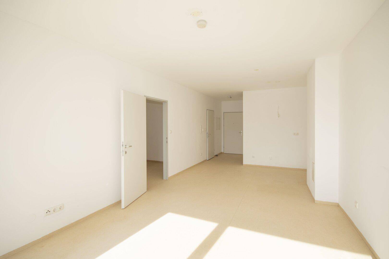 Geräumiger, heller Innenraum mit mehreren Türen und viel Tageslicht.