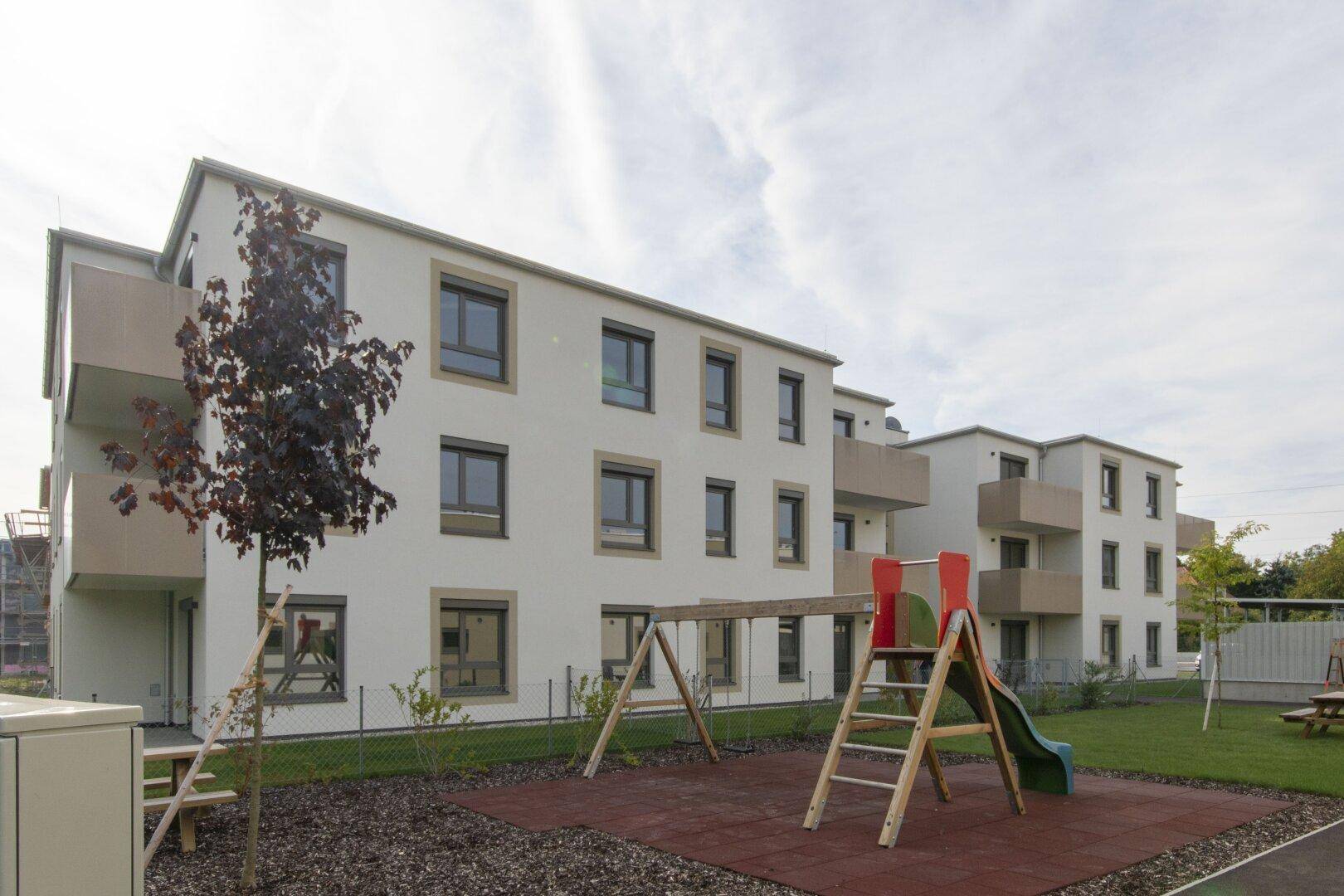 Moderne Wohnanlage mit Spielplatz und Grünflächen für Kinder und Familien.