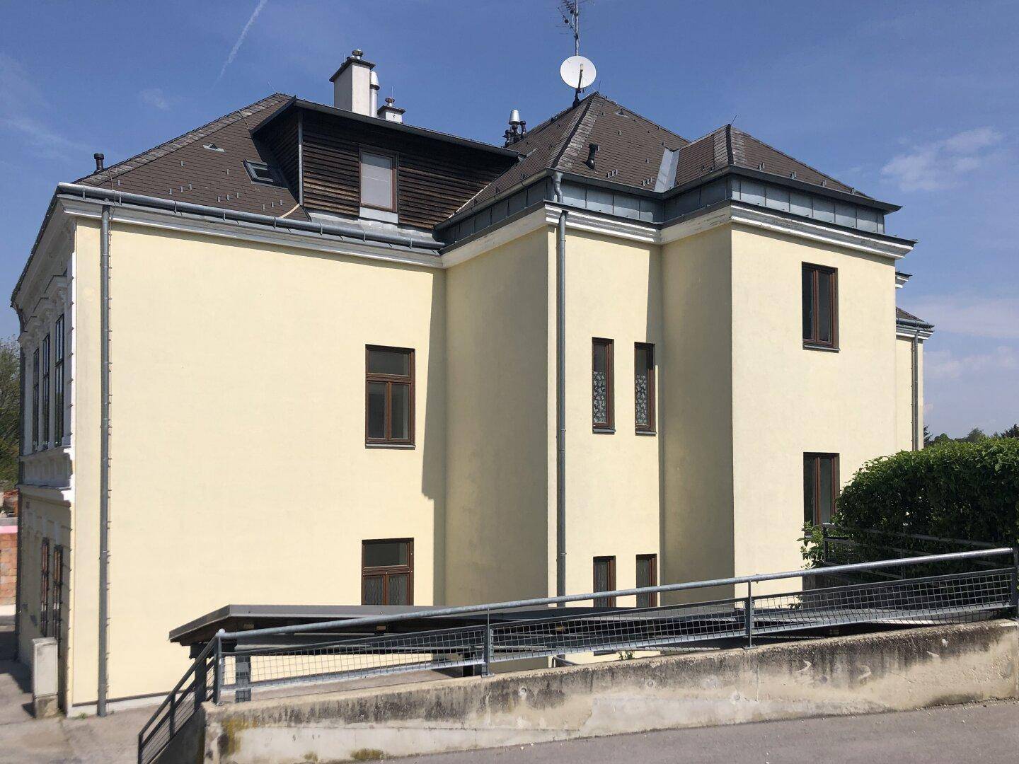 Rückansicht des historischen Gebäudes mit barrierefreiem Zugang über eine Rampe.