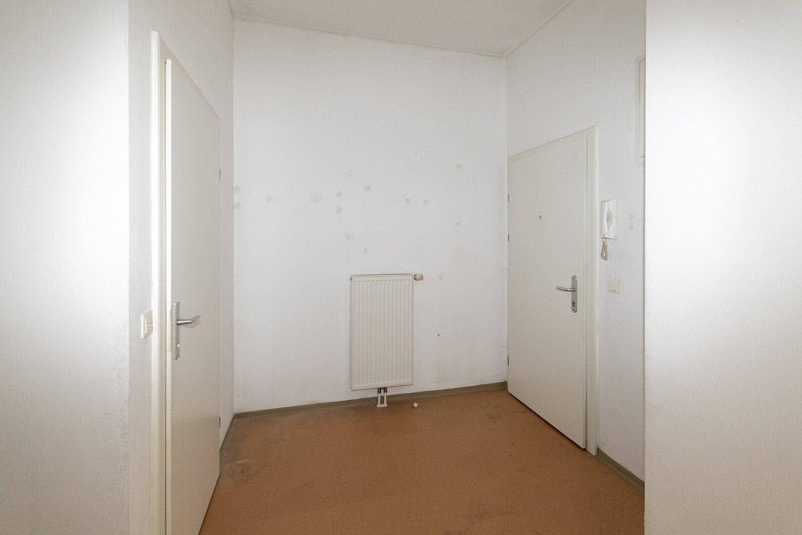 Heller Flur mit Türen und Heizkörper, bietet Zugang zu verschiedenen Bereichen der Wohnung.