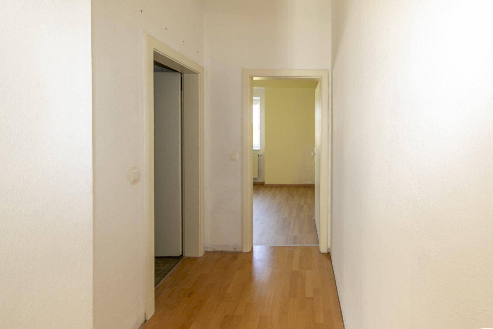 Heller Flur mit Parkettboden und Türen zu angrenzenden Räumen, gut erhalten.