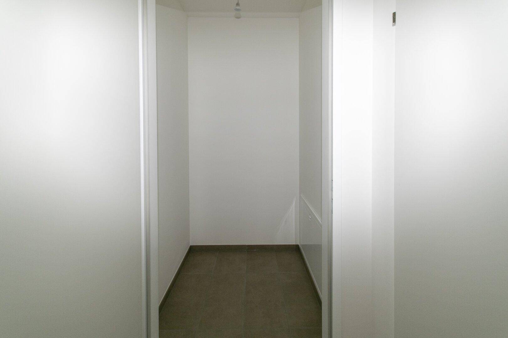 Kleiner, funktionaler Abstellraum mit Fliesenboden und weißen Wänden.