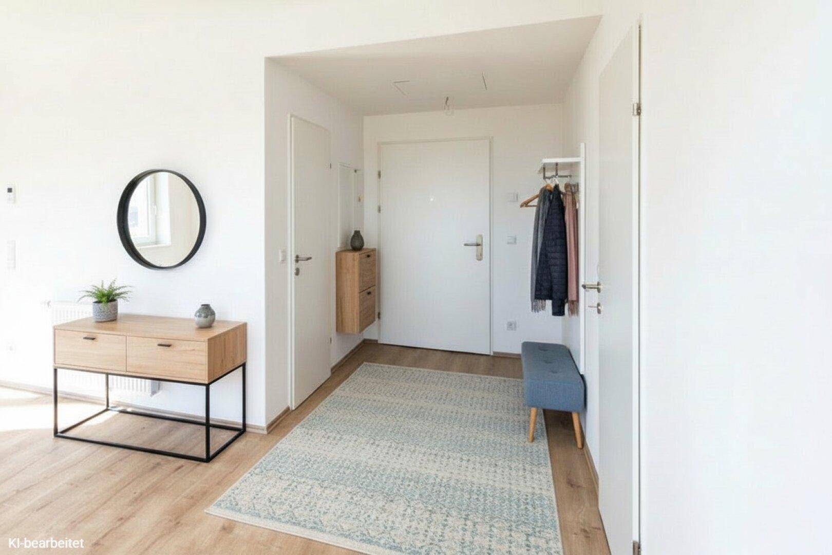 Heller Eingangsbereich mit Garderobe, Spiegel und modernem Sideboard.