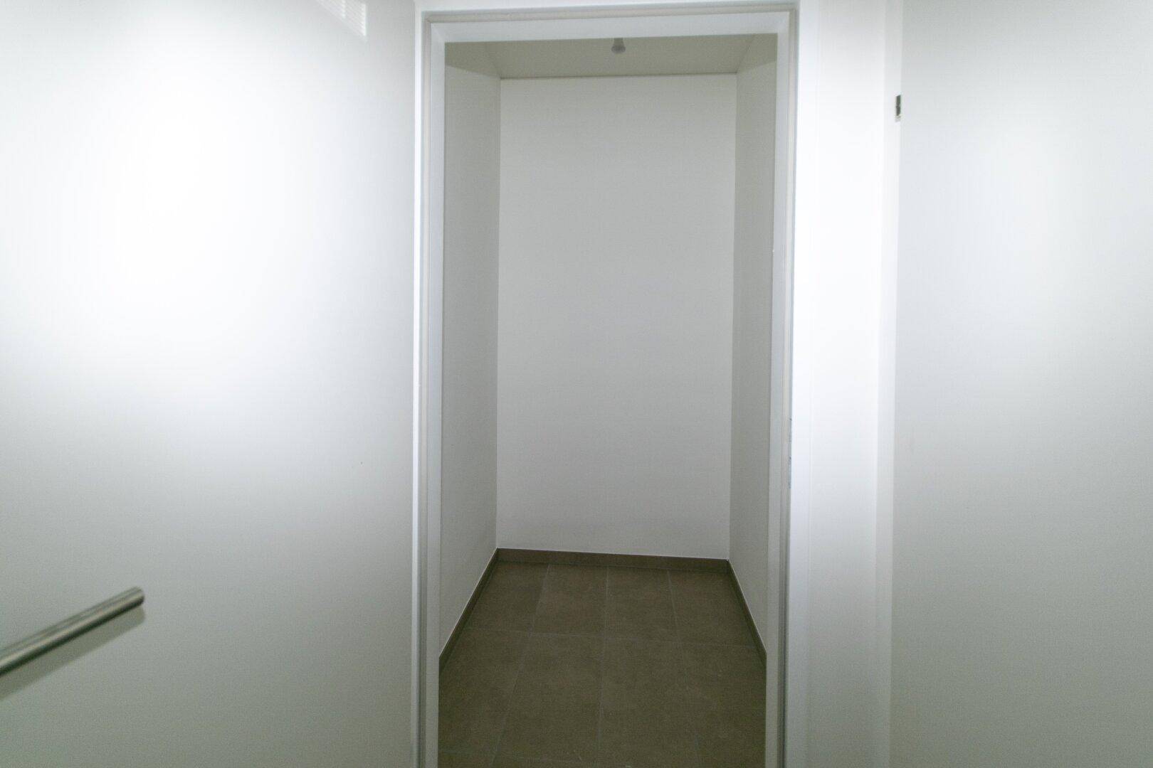 Praktischer Abstellraum mit Fliesenboden und weißen Wänden, ideal für zusätzlichen Stauraum.