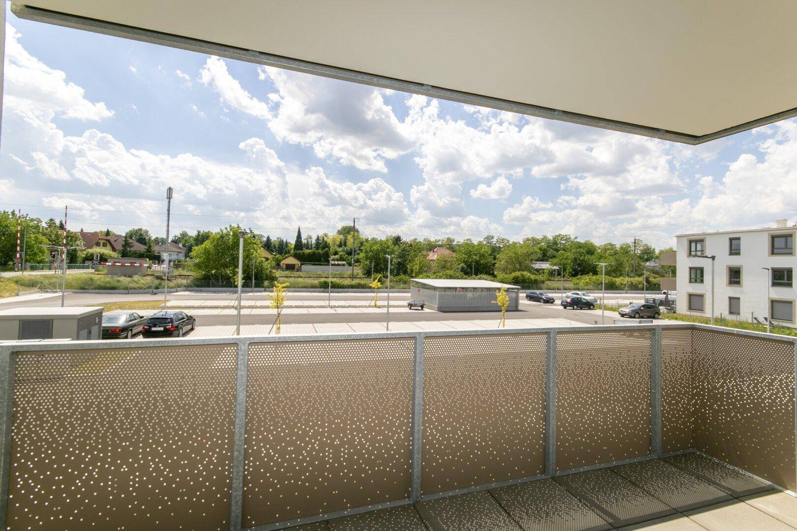 Geräumiger Balkon mit Blick auf die grüne Landschaft und angrenzende Parkflächen.
