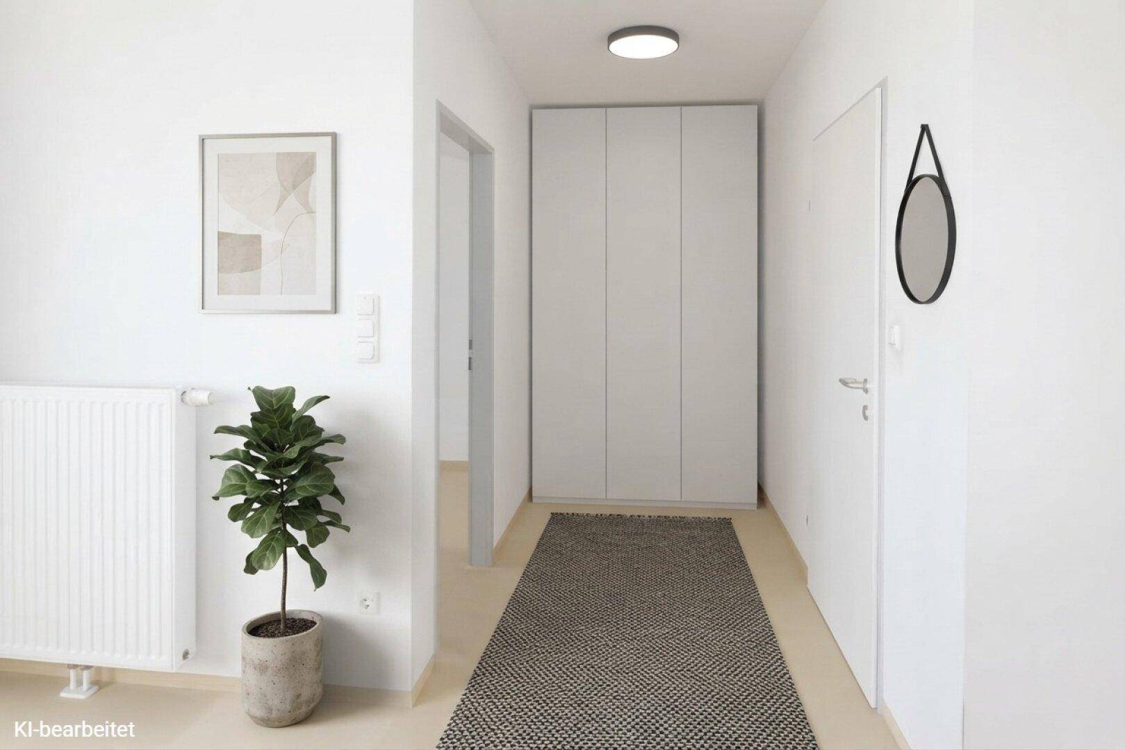 Schlichter Flur mit Einbauschrank, Spiegel und dekorativer Pflanze.