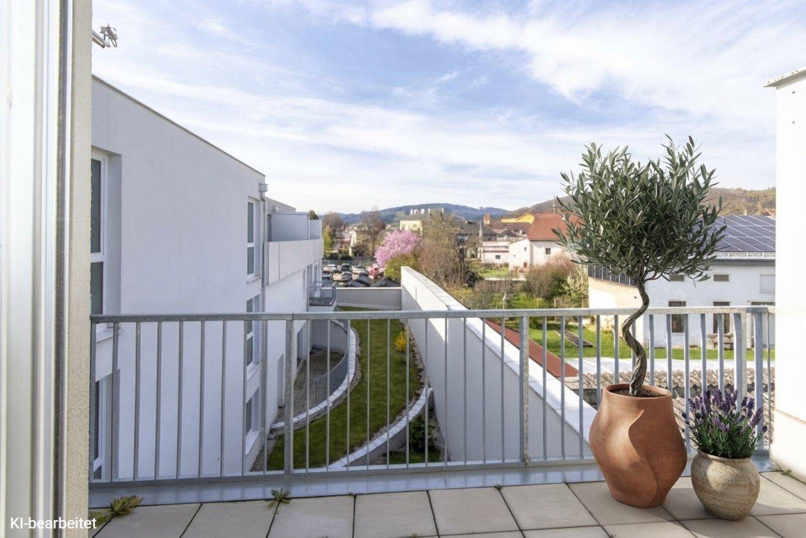 Balkon mit weitem Blick über die Stadt und die umliegende grüne Landschaft.