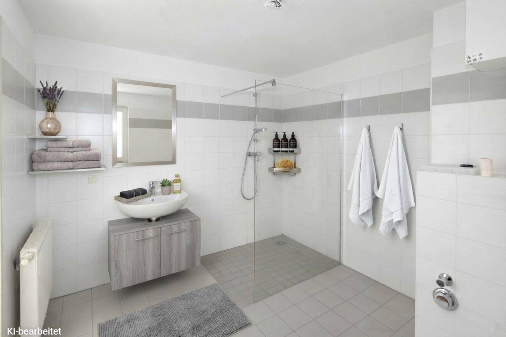 Modernes Badezimmer mit ebenerdiger Dusche, Einzelwaschbecken und hellen Fliesen in Weiß und Grau.