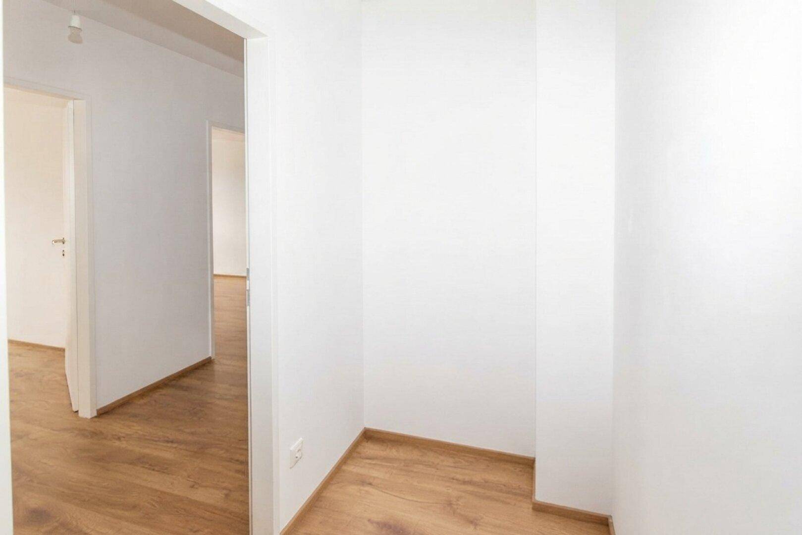 Kleiner, heller Abstellraum mit Laminatboden und weißen Wänden, bietet zusätzlichen Stauraum.
