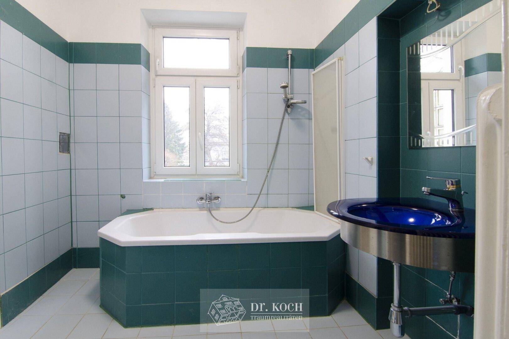 Badezimmer im Stil der 80er Jahre mit grünen Fliesen, Badewanne und Fenster.