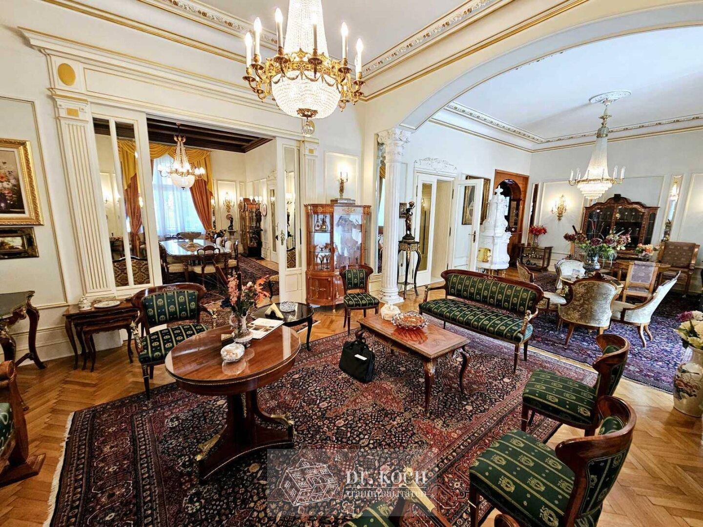 Prunkvolles Wohnzimmer mit edlem Parkettboden, opulenten Möbeln und Kronleuchtern in einem historischen Ambiente.