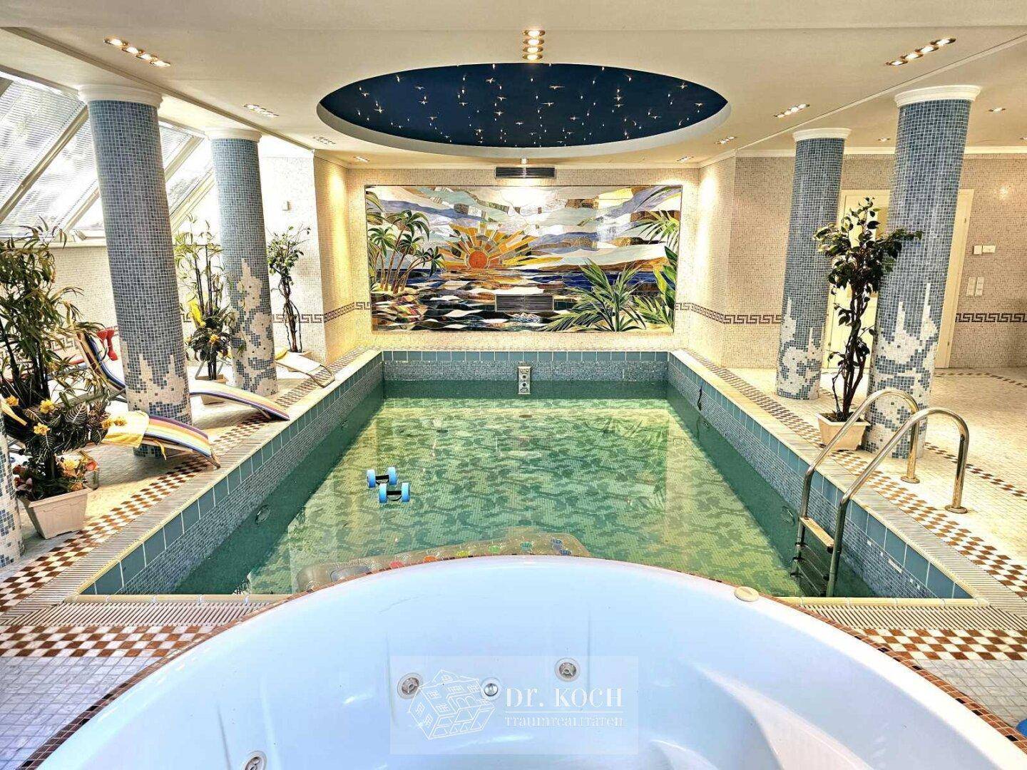 Luxuriöser Innenpoolbereich mit Mosaikfliesen, Whirlpool und dekorativer Wandmalerei.