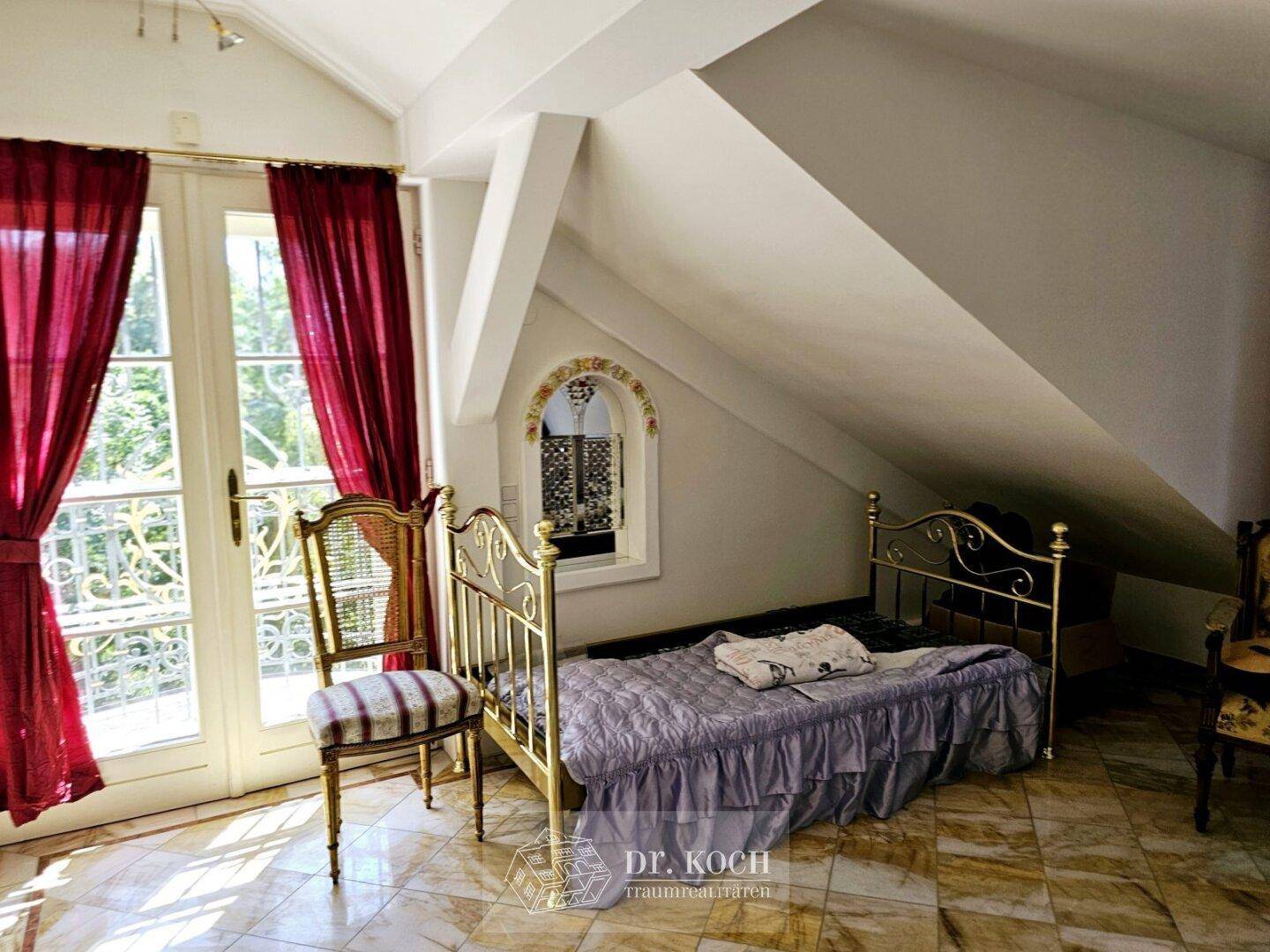 Helles Schlafzimmer im Dachgeschoss mit schrägen Wänden, französischem Balkon und Fliesenboden.