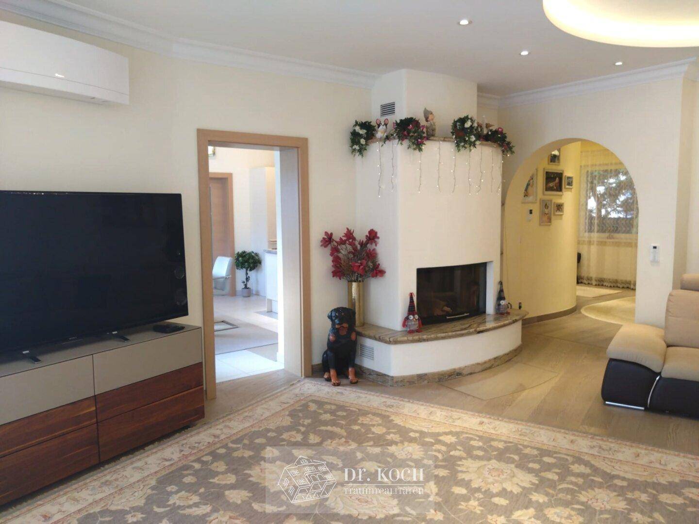 Gemütliches Wohnzimmer mit Kamin, großem Sofa und dekorativem Teppich.