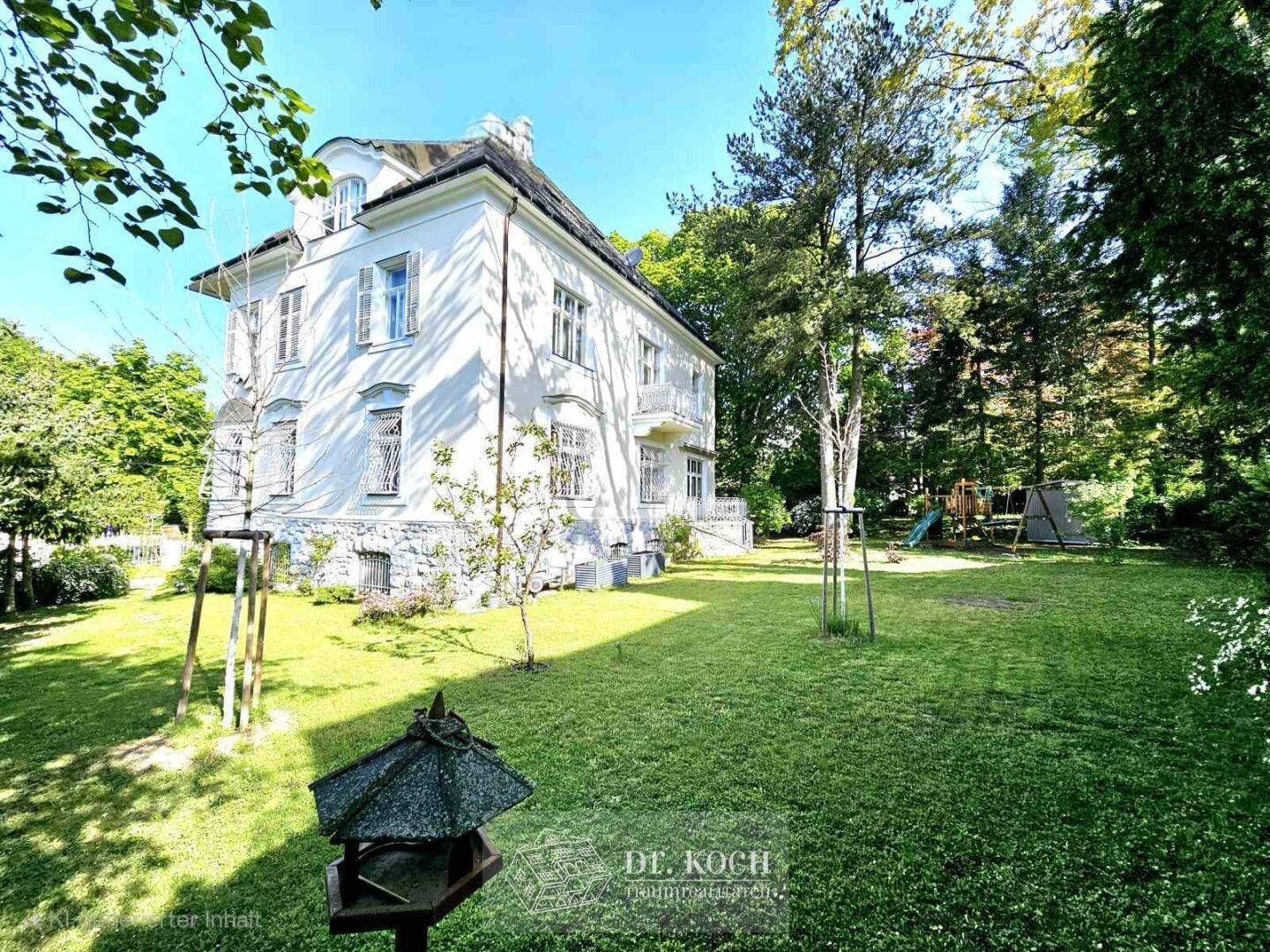 Großer Garten hinter der Villa mit weitläufiger Rasenfläche und Kinderspielplatz.