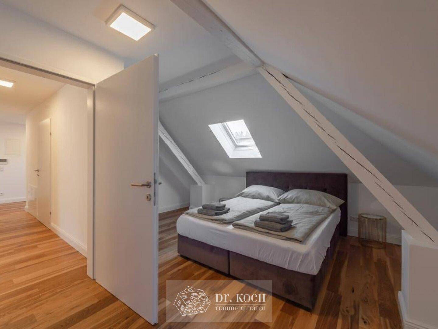 Gemütliches Schlafzimmer im Dachgeschoss mit Doppelbett, Holzboden und Dachfenster.