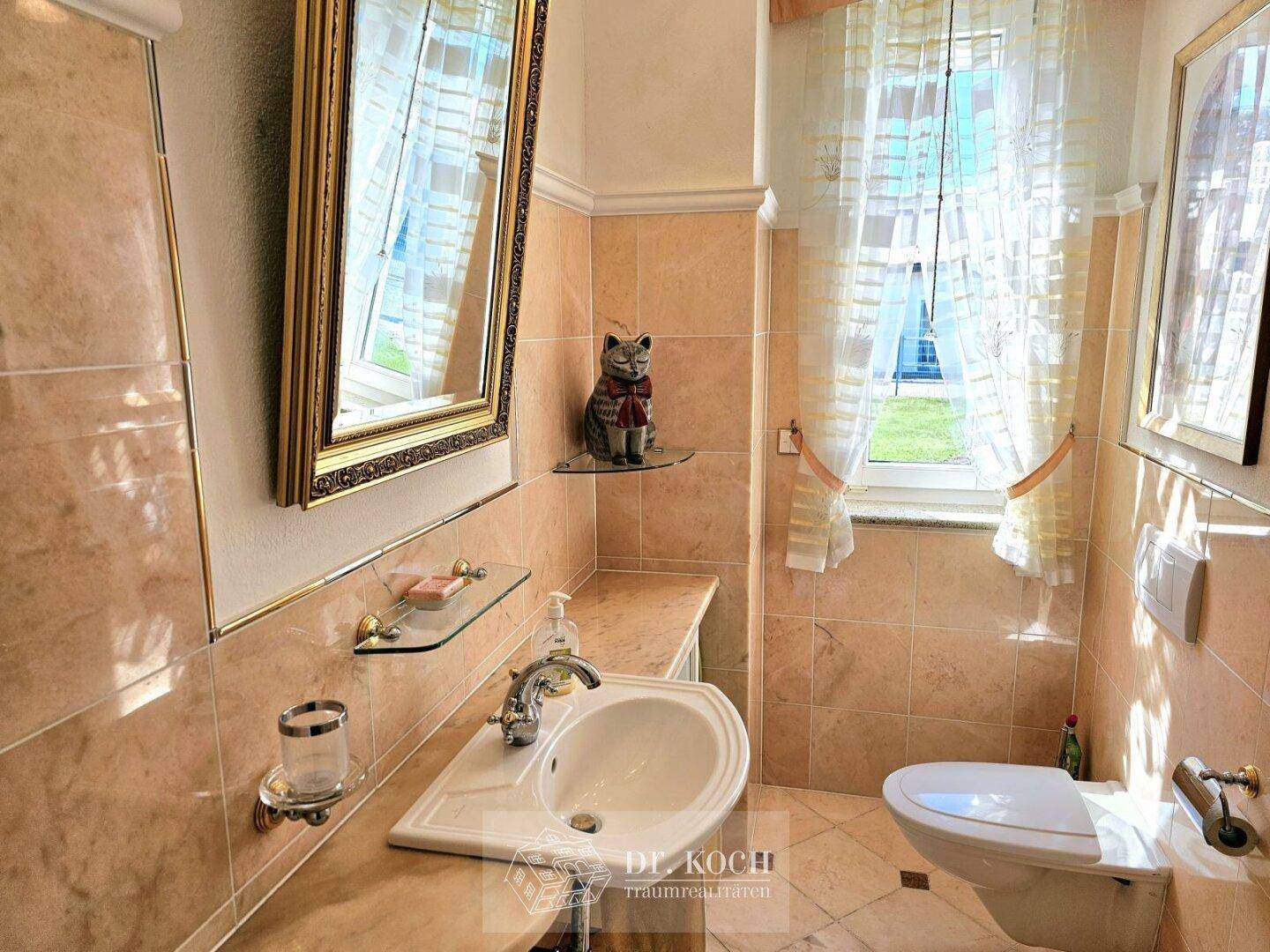 Geschmackvolles Gäste-WC mit beigefarbenen Fliesen, Einzelwaschbecken und Fenster für Tageslicht.